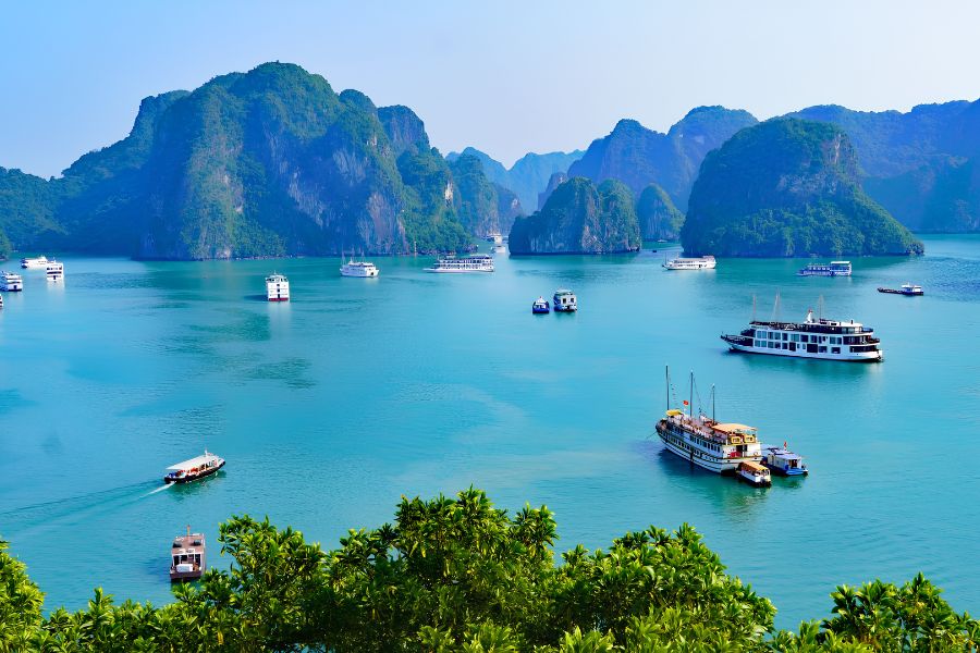 Luxury wooden cruise sailing through the emerald waters of Lan Ha Bay in Vietnam