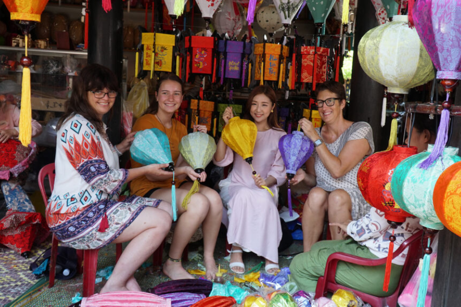 Traveler crafting a bespoke silk lantern in a private courtyard atelier with a Hoi An master artisan