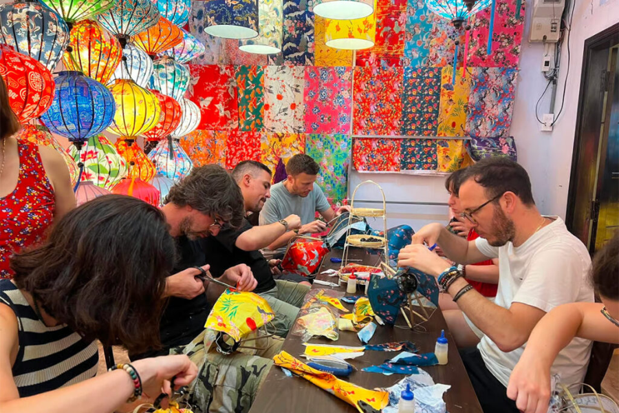 Artisans crafting handmade bamboo and cellophane star lanterns inside a traditional workshop in Vietnam