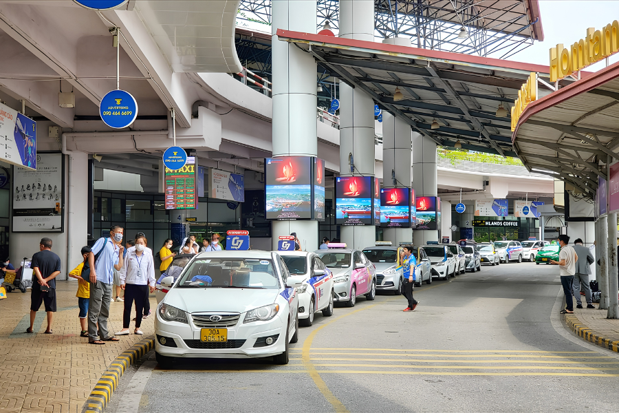 Fleet of electric taxis lined up outside an airport terminal in Vietnam for passenger pickups