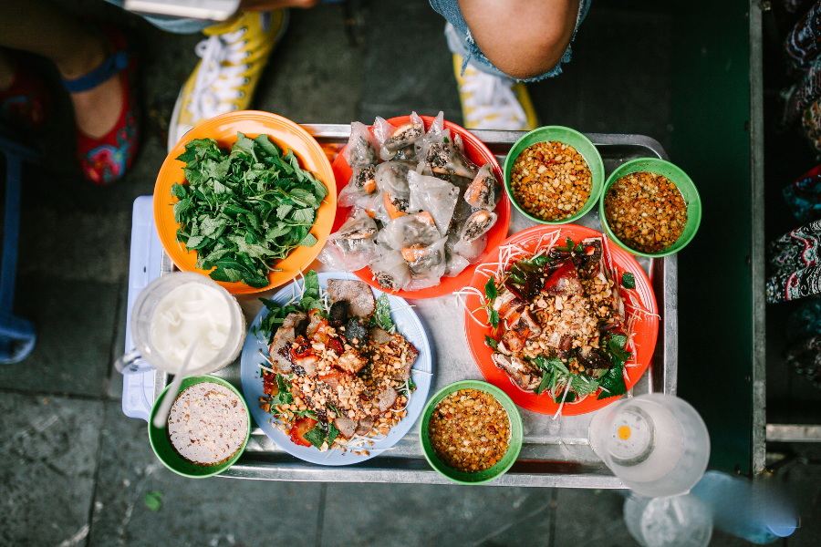 Refreshing street-side plate of shredded green papaya salad topped with sweet and spicy dried beef jerky, roasted peanuts, and fresh Vietnamese balm herbs
