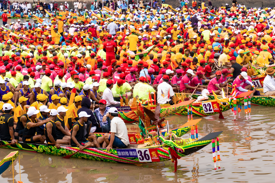 Traditional long Ghe Ngo racing boats powered by synchronized rowers competing on the river in the Mekong Delta. 