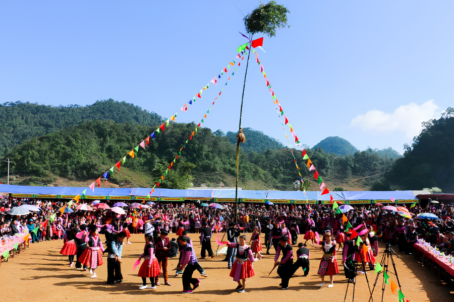 Ethnic minority locals playing traditional bamboo panpipes and dancing on terraced hillsides in northern Vietnam.