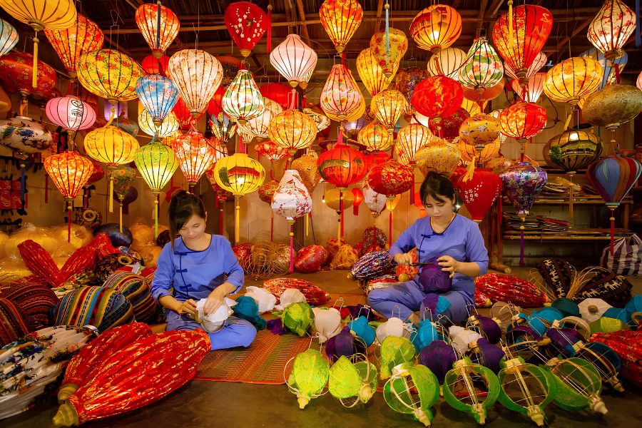 Colorful, handmade silk lanterns glowing in the evening outside a traditional merchant shophouse in the ancient town of Hoi An