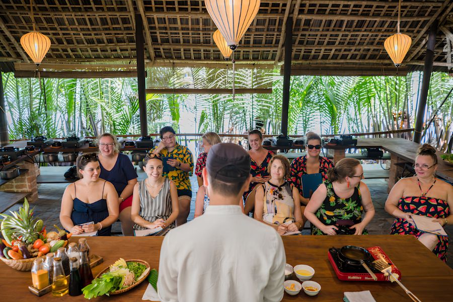 Fresh local ingredients, rice batter, and herbs prepared for cooking crispy banh xeo pancakes in a riverside cooking class