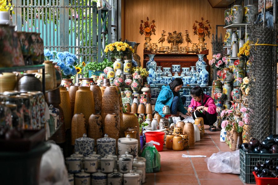 Hand-thrown ceramic pottery and crackle-glazed blue-and-white porcelain teapots displayed inside a traditional kiln workshop in Bat Trang village