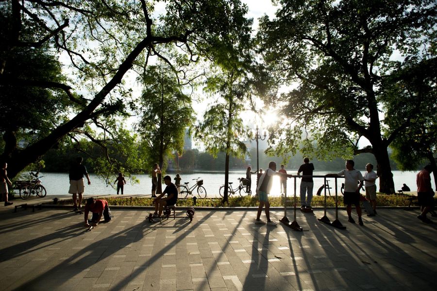 Misty morning view of Hoan Kiem Lake in Hanoi with weeping willow branches framing the ancient Turtle Tower in early light