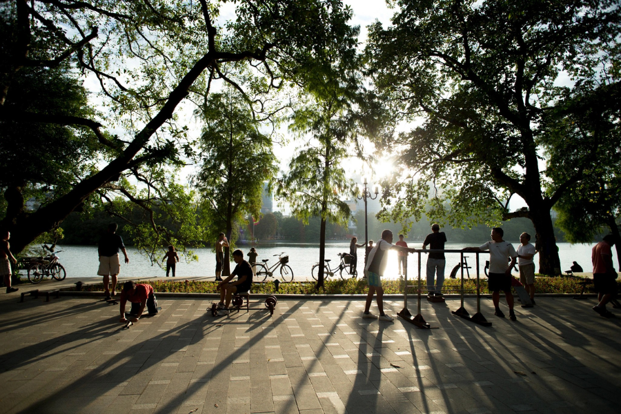 Misty morning view of Hoan Kiem Lake in Hanoi with weeping willow branches framing the ancient Turtle Tower in early light
