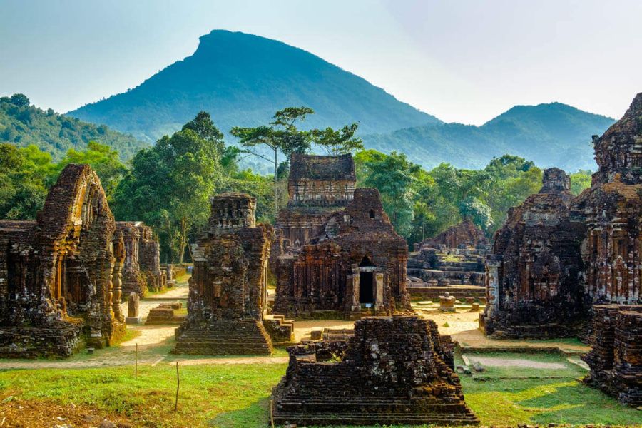 Ancient red-brick Hindu temple towers of My Son Sanctuary surrounded by lush jungle and mist in Central Vietnam