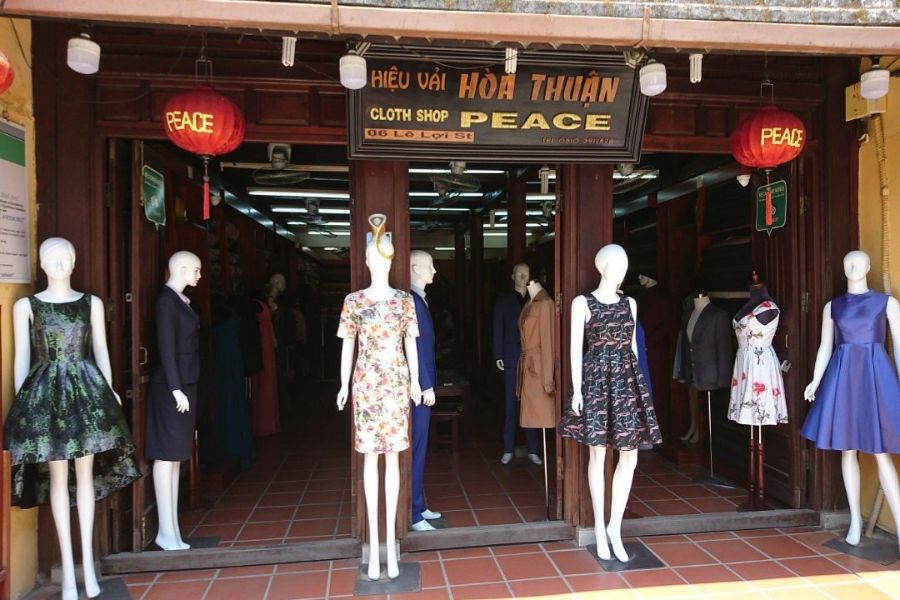 Customer choosing fabric with staff at Peace Cloth Shop in Hoi An