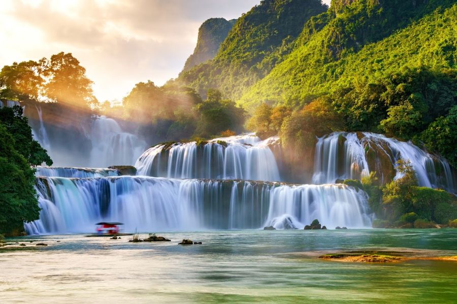 Wide cascades of Ban Gioc Waterfall flowing between green hills in Cao Bang, Vietnam