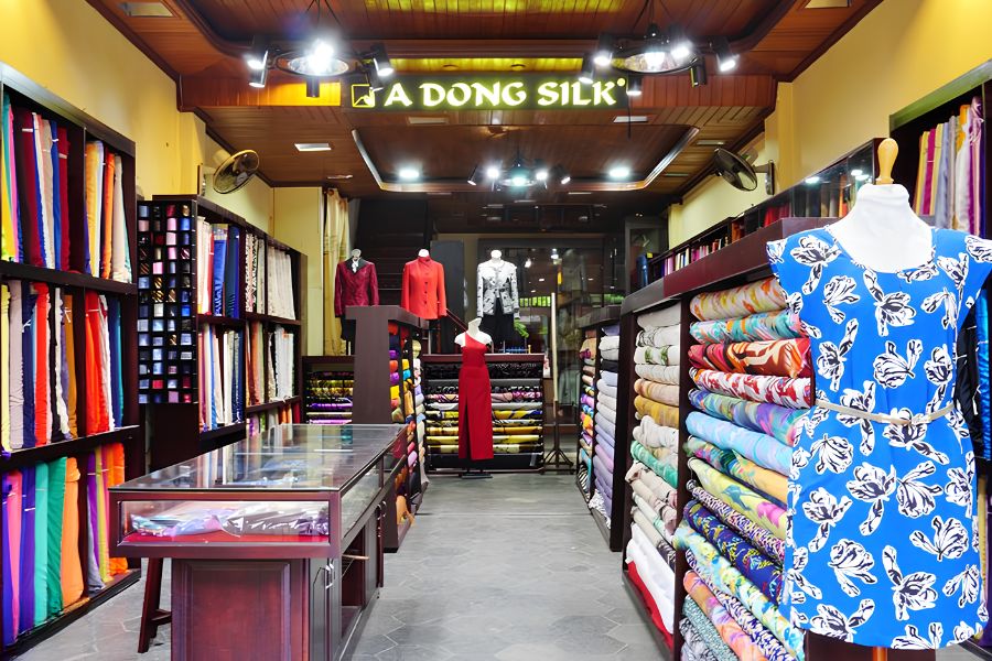 Selection of suit fabrics and custom garments displayed at A Dong Silk in Hoi An